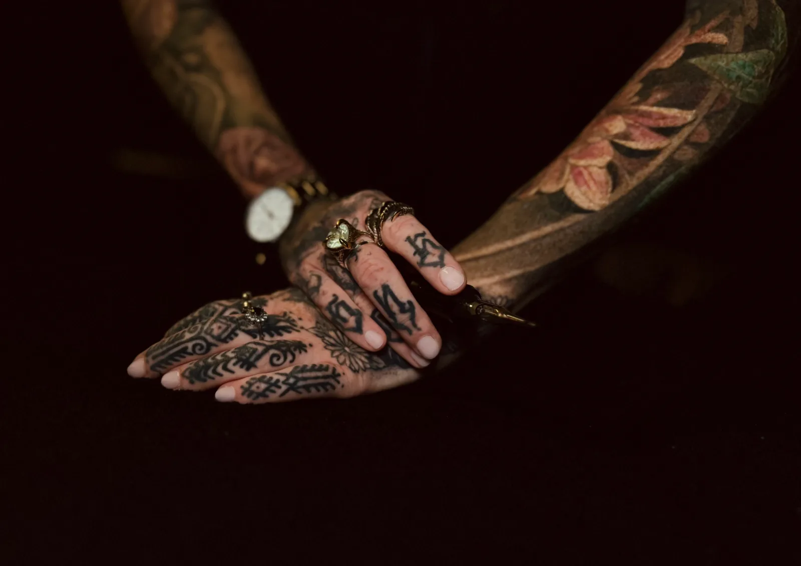 Nadine's hands hand-poking a tattoo