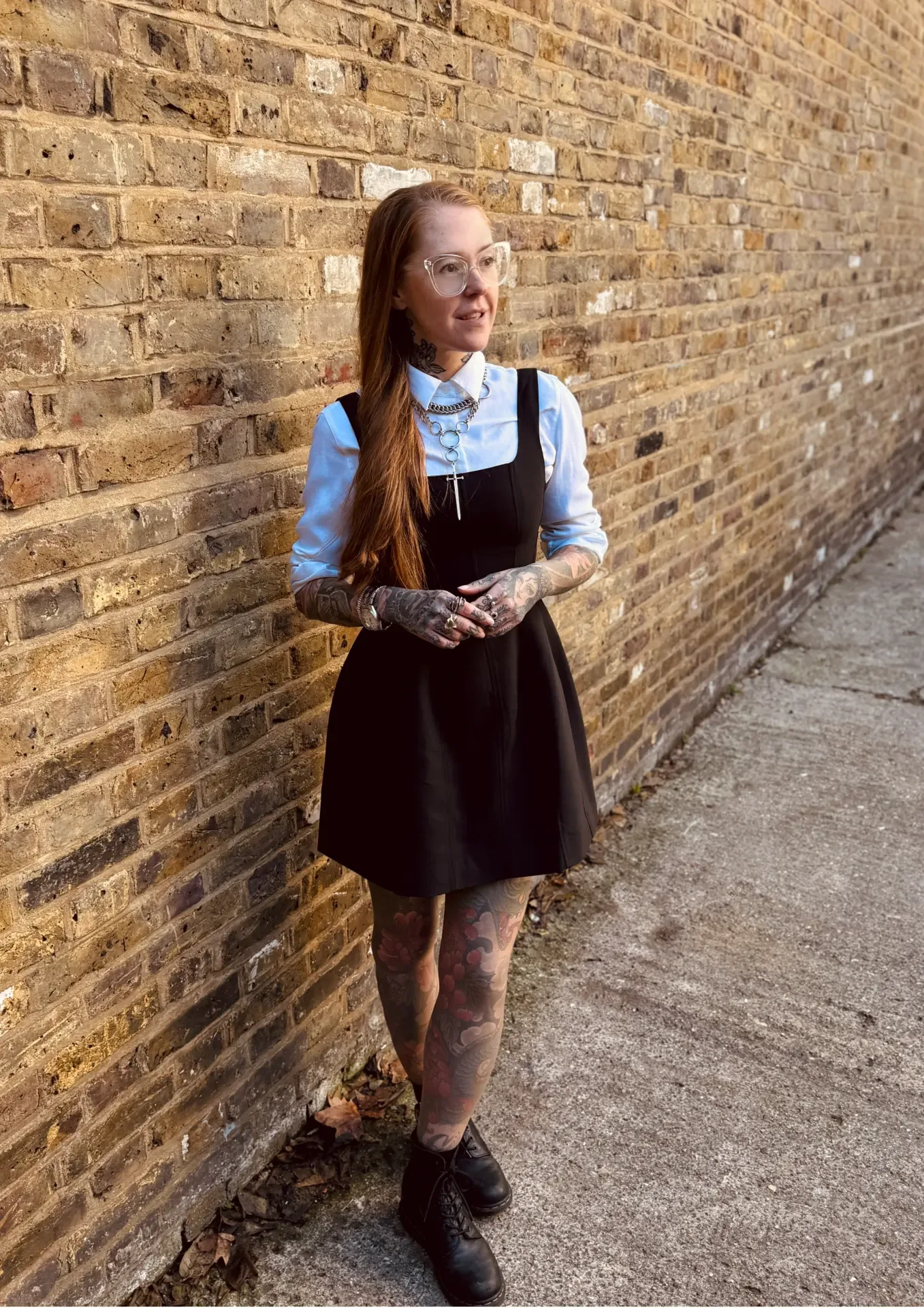 Nadine standing in front of a brick wall in London