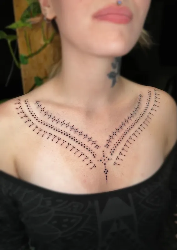 Hand-poked ornamental collar piece framing the neckline