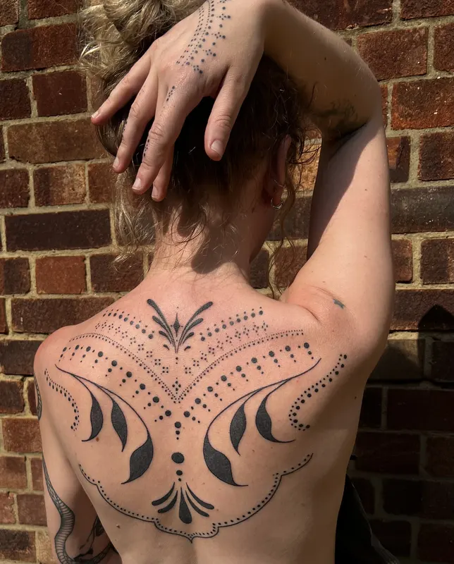 Large ornamental dotwork piece across the upper back