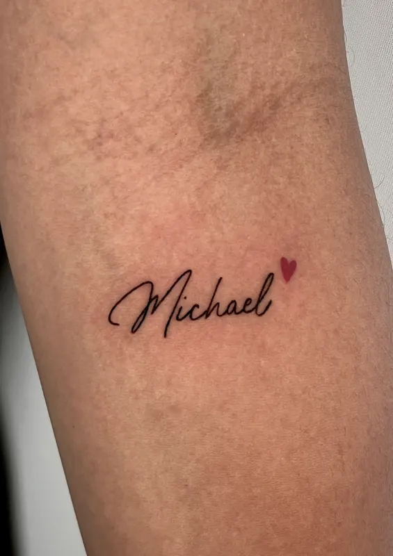 Hand-poked script reading Michael with a small red heart